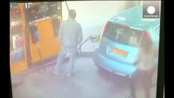 frau laesst zapfsaeule und auto