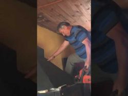 mann saegt sich mit kettensaege